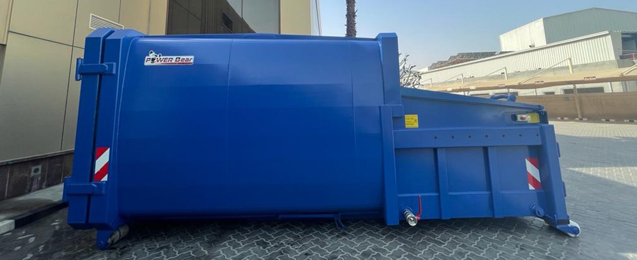 Blue waste compactor unit placed outside a commercial building